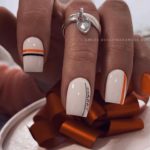 Бело-оранжевый маникюр с полосками и надписями на квадратных ногтях