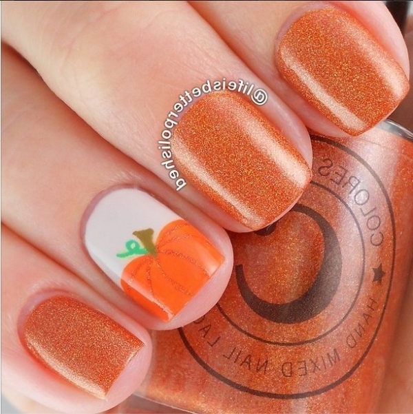 Дизайн ногтей ораньжевого цвета с блестками, на хеллоуин, с рисунком тыквы.
