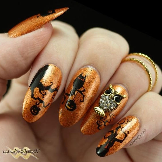 Яркий оранжевый маникюр к празднику Хеллоувин со стразами сова на длинных ногтях миндальной формы