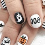 Маникюр на короткие ногти в стиле хеллоуин с рисунком приведения тыквы паучков на белых ногтях