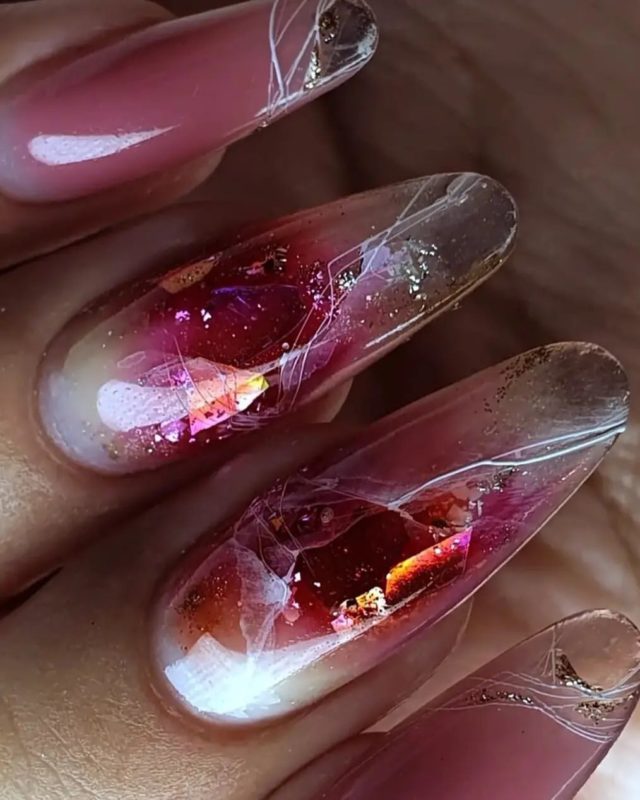 Праздничный аквариумный маникюр с блестками на длинных овальных ногтях