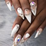 Богатый свадебный дизайн ногтей в белом цвете с декором из страз и камней на длинных ногтях формы пика