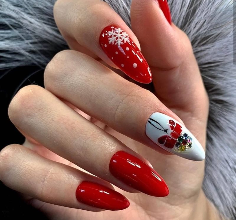 Яркий красный новогодний дизайн на миндальных ногтях со стразами и рисунком снежинки