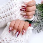 Яркий новогодний дизайн ногтейв бордовом и бежевом цвете с принтом свитера, рисунком снежинок, шариков и оленя