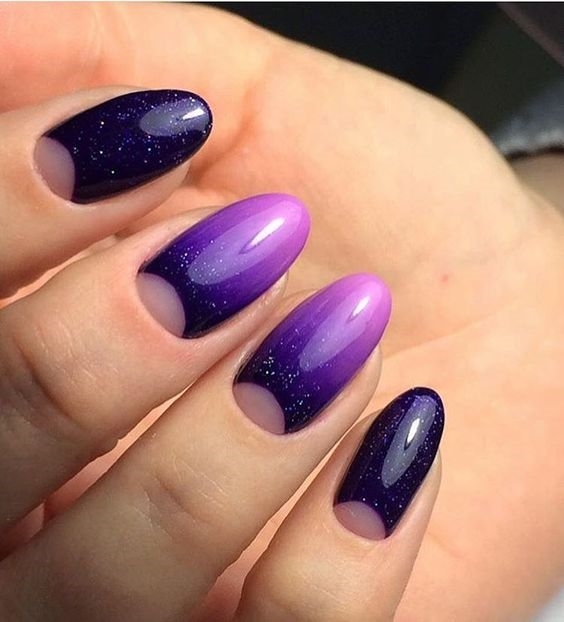 Космический маникюр в фиолетовых тонах с лунками, омбре и растяжкой блесток на овальных ногтях