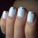 Лунный белый маникюр с серебристой лентой имитирующей френч на коротких ногтях формы мягкий квадрат