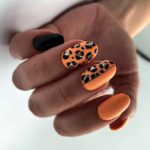 Маникюр на короткие овальные ногти с леопардовым принтом в черно-оранжевом цвете