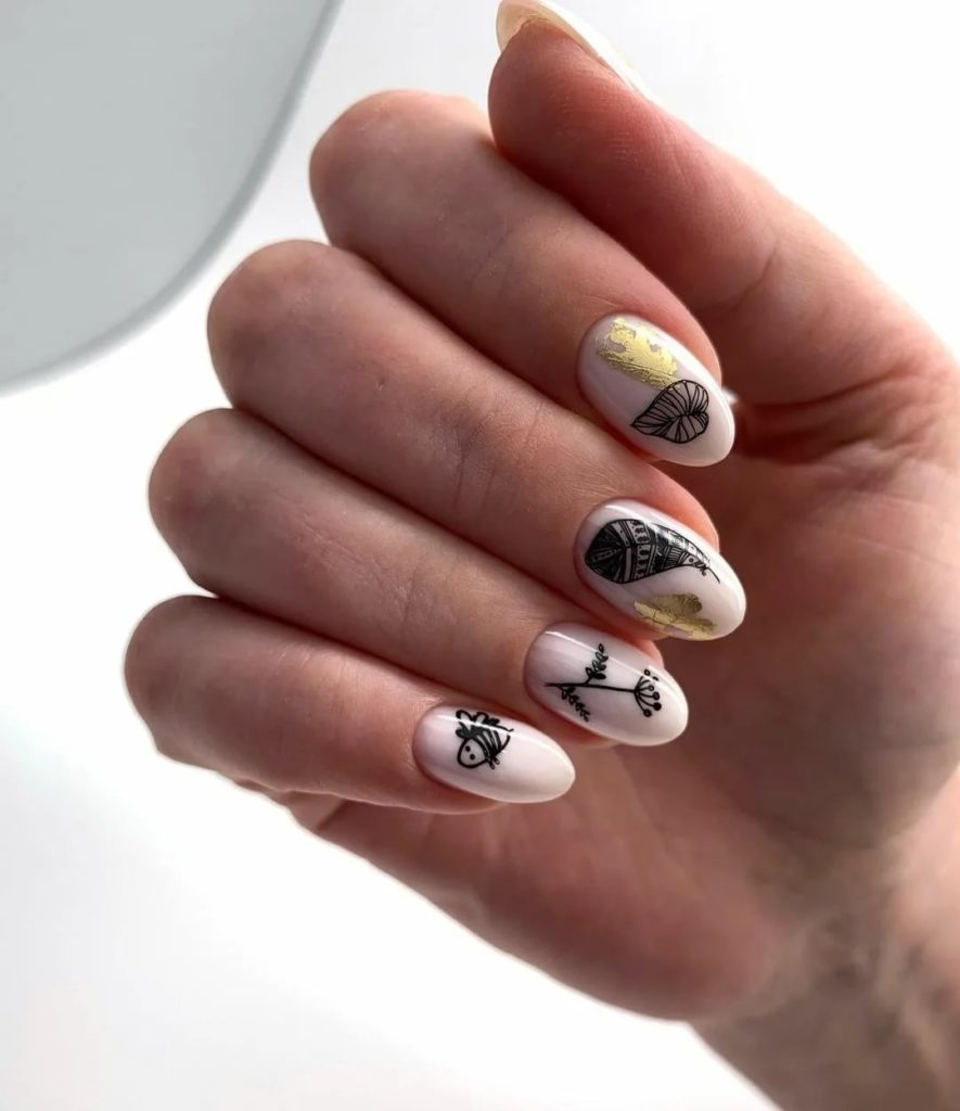 Оригинальный дизайн ногтей с силуэтами черных цветов и листьев на белом фоне овальных ногтей средней длины