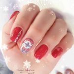 Праздничный яркий зимний дизайн ногтей красного цвета со снежинками и новогодними наклейками