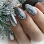 Серебристый зимний дизайн с рисунком снежинок и глиттером на миндальных ногтях