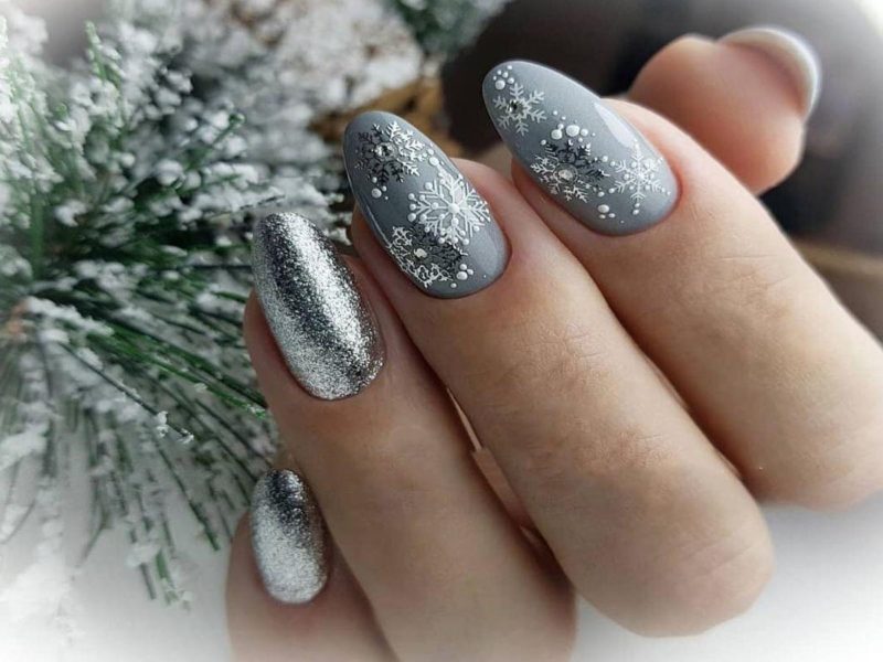 Серебристый зимний дизайн с рисунком снежинок и глиттером на миндальных ногтях