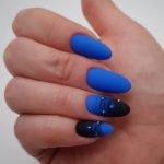 Зимний маникюр насыщенного синего цвета на миндальных ногтя с декором техники паутинки и страз