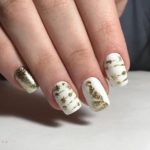 Белый маникюр с золотыми новогодними рисунками на ногти средней длины