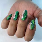 Глянцевый маникюр на ногти овальной формы с яркими мраморным дизайном разных оттенков зеленого