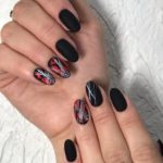 Идея оформления ногтей в черном матовом цвете с декором из красной фольги и нитевидных полосок