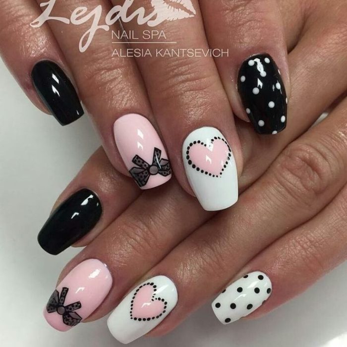 Кокетливый маникюр в белом, розовом и черном цвете с дизайном из бантиков и сердечек на средние квадратные ногти