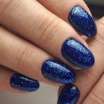 Космический темно-синий маникюр с блестками на короткие ногти овальной формы