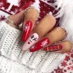 Креативный рождественский маникюр красного цвета с дизайном в клетку и рисунком оленя на длинные ногти миндальной формы