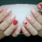 Нежный маникюр кремового цвета с ярким красным оформлением безымянного ногтя