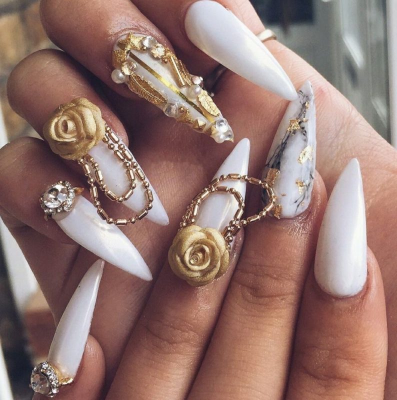 Оформление ногтей стилетов в бело-золотом цвете с крупным объемным декором