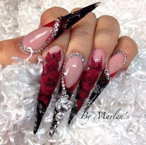 Оформление очень длинных ногтей стилетов в красно-черном цвете со стразами и цветочными наклейками
