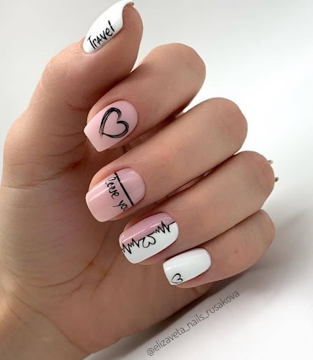 Популярный вариант оформления ногтей в бело розовом цвете с надписями и рисунками