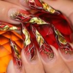 Праздничное оформление ногтей-стилетов в красно-золотистом цвете с блестками