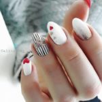 Привлекательный белый маникюр с дизайном из сердечек и глиттером на ногти средней длины формы миндаль