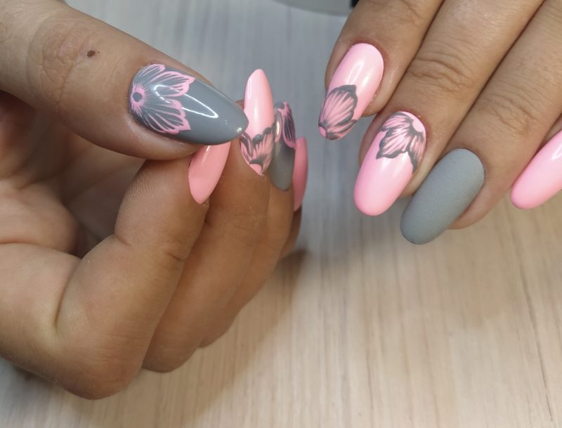 Серо-розовое оформление ногтей овальной формы с рисунками цветов, выполненными вручную
