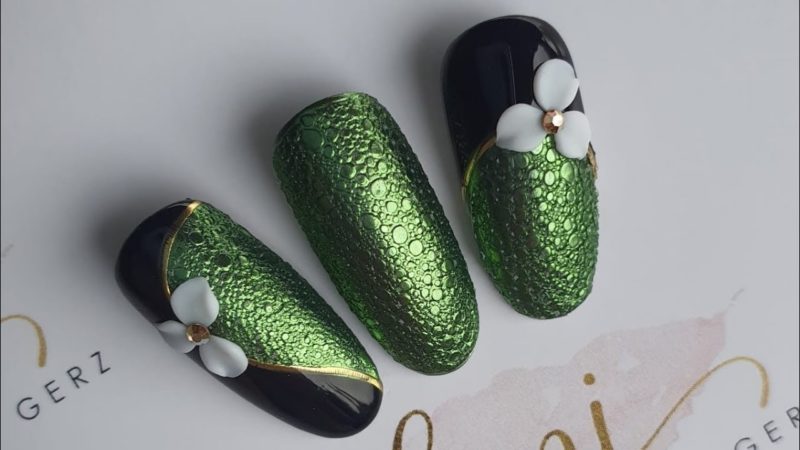 Зеленое оформление ногтей с узором Змеиная кожа и объемным декором в виде лилий