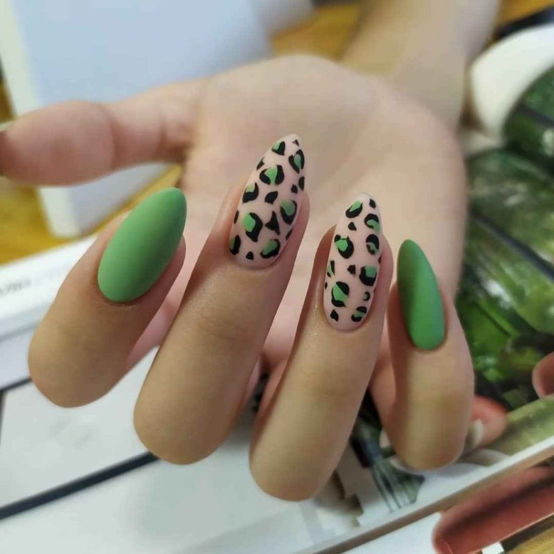 Зеленый матовый маникюр с ярким леопардовым принтом на светлом фоне двух ногтей