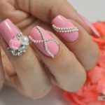Женственные розовые ногти с объемным украшением в виде миниатюрных бус и цветов со стразами