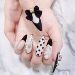 Бело-черный дизайн ногтей в стиле пин-ап с жемчугом, объемным бантиком и рисунком-горохом