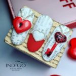 Бело-красный дизайн ногтей с надписями по светлой основе, крупным декором в виде сердечек