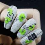 Дизайн ногтей в светлом цвете с эффектом перепелиного яйца и зелеными лепестками ручной лепки
