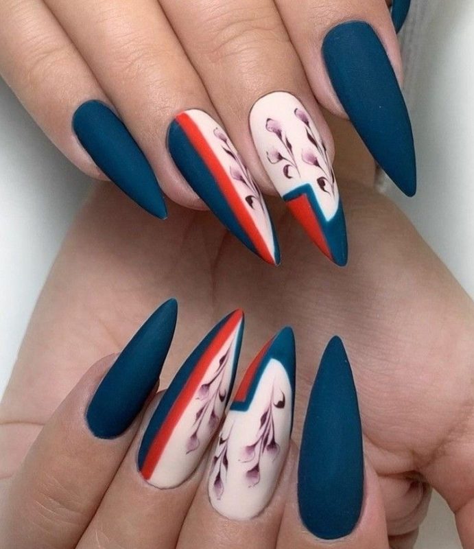 Ногти формы стилет в насыщенном синем цвете с розовыми и красными вставками, схематичными рисунками цветов