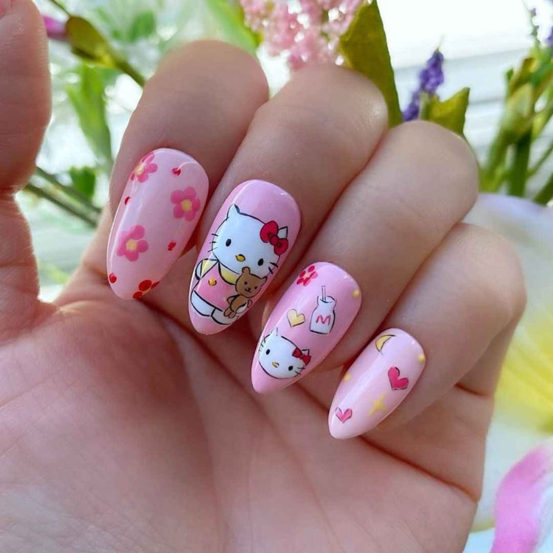 Оформление миндальных ногтей в стиле Hello Kitty с рисунками мультяшной кошечки и цветов