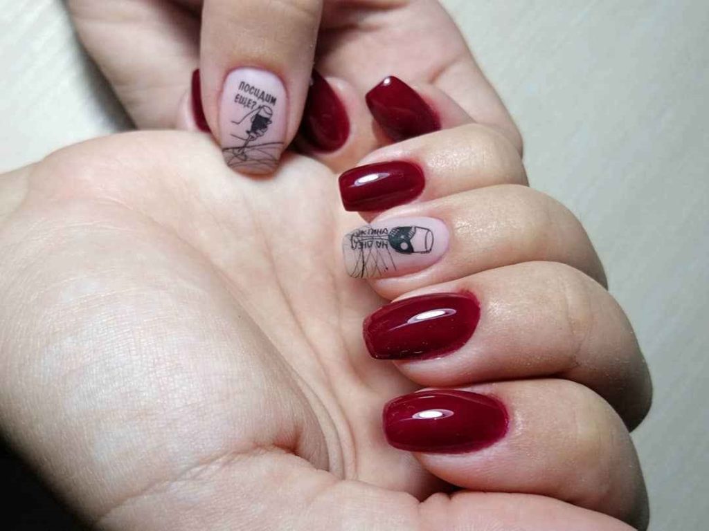 Оформление ногтей винного цвета с черными рисунками руки с бокалом и тематическими надписями