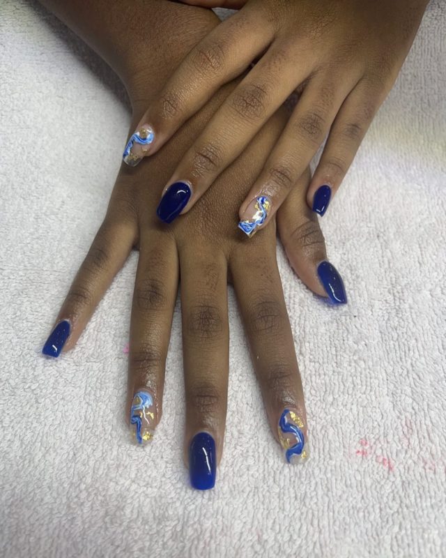 Синий глянцевый дизайн ногтей с узором в виде волн и золотистой фольгой