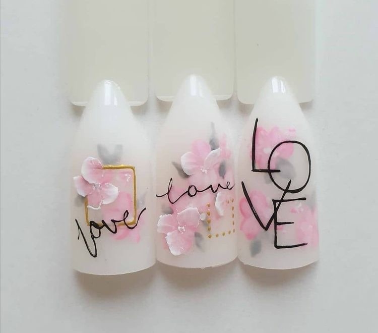 Весенний вариант оформления ногтей в розовом и белом цвете с цветочными рисунками и золотистыми вставками