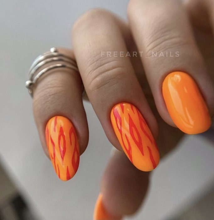 Яркий сочный дизайн ногтей в оранжевом цвете с контрастными рисунками в виде пламени