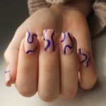 Дизайн ногтей в нюдовом оттенке с хаотичным рисунком фиолетовой волнистой линией