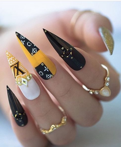 Ногти-стилеты с брендовым оформлением Louis Vuitton в черном, белом и желтом цвете со стразами