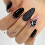 Оформление ногтей в черном и розовом цвете с крупными декоративными ногтями на поверхности