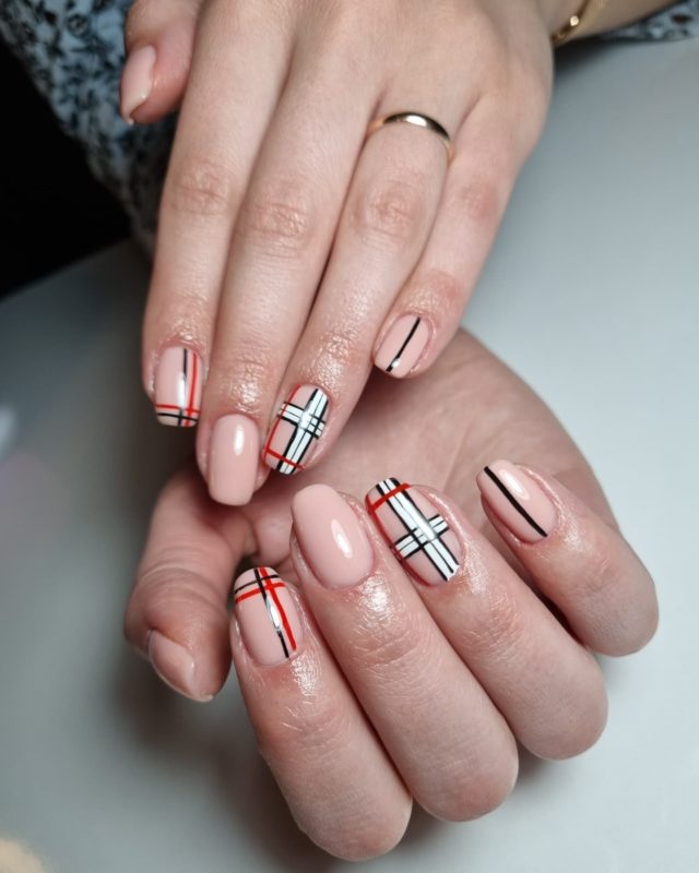 Светло-розовый дизайн ногтей с клетчатыми вставками на четырех пальцах
