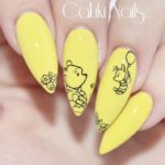 Желтый глянцевый маникюр на заостренные ногти с простыми черными рисунками Пятачка и Пуха