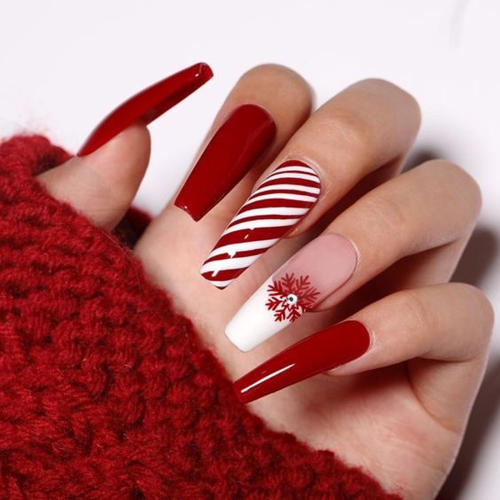 Алый яркий дизайн ногтей на зимнюю тему с рисунками снежинок, контрастными полосами