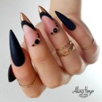 Длинные ногти-стилеты в черном матовом цвете со стразами и золотистыми кончиками