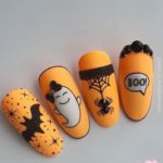 Яркий оранжевый дизайн ногтей на тематику Хэллоуина с рисунками пауков, привидений, летучих мышей