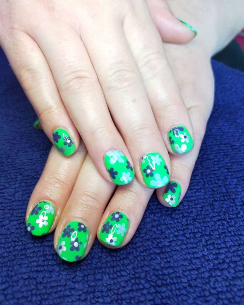 Короткие ногти круглой формы ярко зеленого цвета с цветочным рисунком